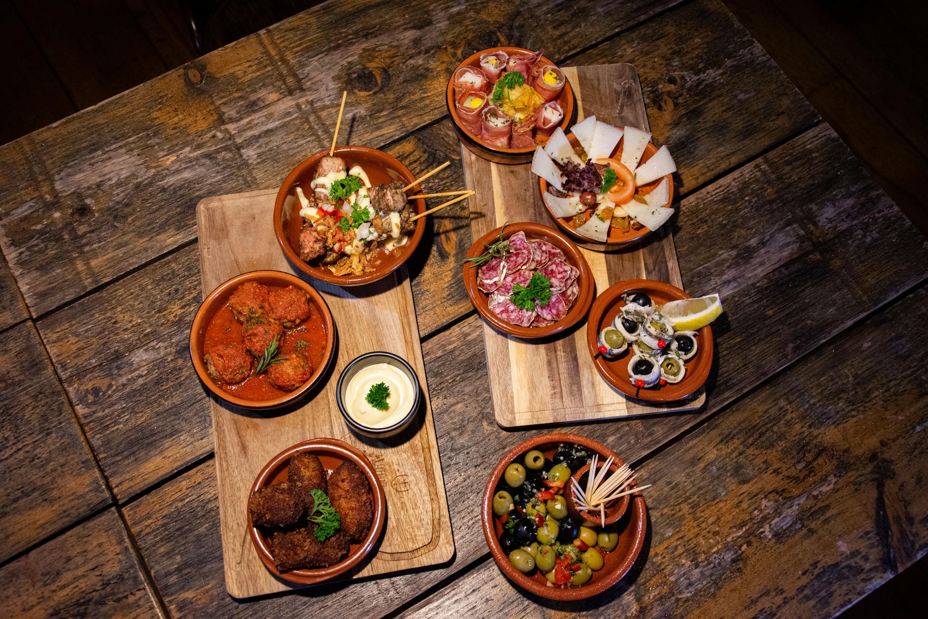 Vielfältige Tapas-Auswahl auf einem Holztisch